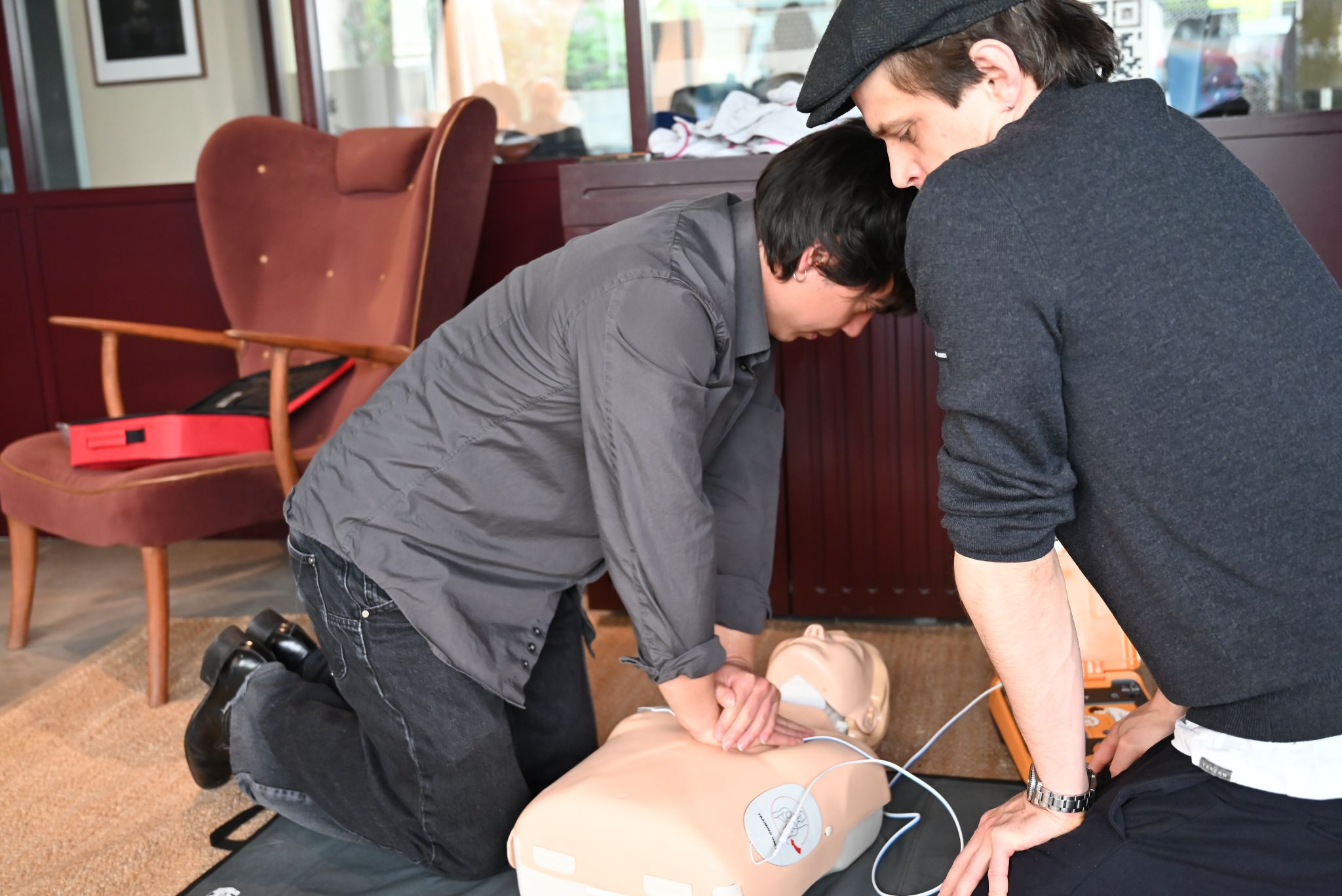 Erste-Hilfe-Schulung: Zwei Personen üben die Herzdruckmassage an einer Reanimationspuppe – ideal kombinierbar mit der Feuerlöscher Schulung.
